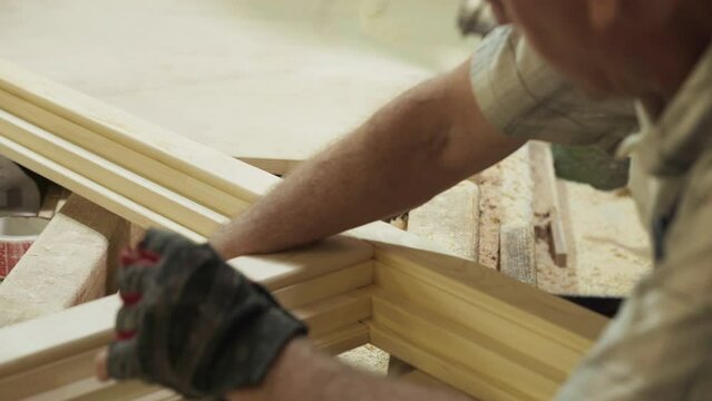 Close Up Of Carpentry Production Master Making Marks On Wooden Plank With Pencil. Master Manually Producing Woodwork For Carpentry. Master Crafts Wooden Window Frame. Carpentry Production Workshop