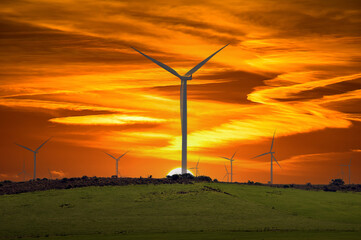 A wind turbine against the rising sun.  Environmentally friendly electricity supply.