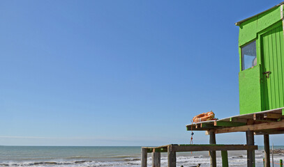 Torre salvavidas verde en una playa en la costa atlántica un día de verano con el cielo azul.