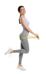 Happy young woman with measuring tape showing her slim body against white background