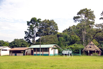 Fototapeta premium Houses and buildings around a large field in Puerto Bolivar, in the Cuyabeno Wildlife Reserve, outside of Lago Agrio, Ecuador