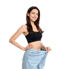 Happy young woman in big jeans showing her slim body on white background - obrazy, fototapety, plakaty