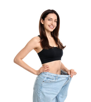 Fototapeta Happy young woman in big jeans showing her slim body on white background