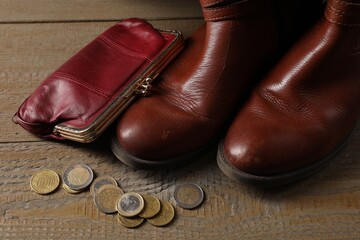 Poverty. Old boots, wallet and coins on wooden table - obrazy, fototapety, plakaty