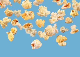 Fotobehang Tasty fresh popcorn flying on light blue background © New Africa