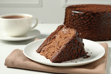Piece of delicious chocolate truffle cake on white table, closeup
