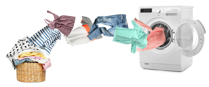 Clothes flying from laundry basket into washing machine on white background