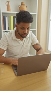 Confident african american man giving thumbs-up sign while using laptop at home, radiating positive energy and success