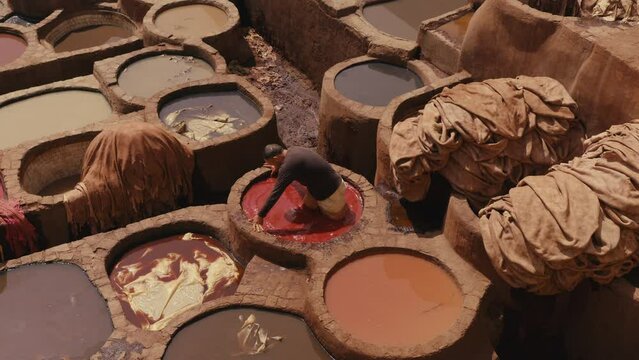 Top view of worker Soaking leather into the red Dye Pool