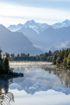 Lake Matheson : Iconic View of the Aoraki Mount Cook and Mount Tasman mountains reflected on the still water, West coast, New Zealand