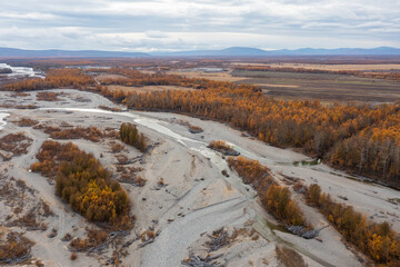 Autumn aerial view of the river valley. Top view of the river and forest. Mountains in the distance. Northern nature. Travel to Siberia and the Russian Far East. Ola river, Magadan Region, Russia. - 778597956