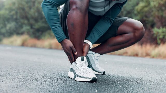 Fitness, ankle and hands rub injury, accident or pain at race, competition or marathon training. Sports, health and closeup of black man athlete with leg muscle sprain for cardio exercise or workout