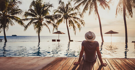 people in luxury beach hotel with luxurious swimming pool at sunset, tropical holidays vacation, tourism and travel background banner - 778618757