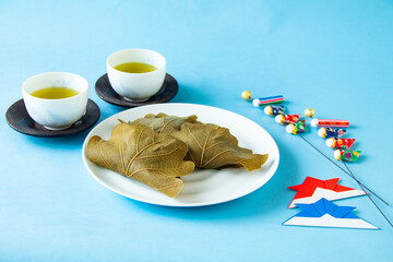 子供の日　美味しい柏餅と鯉のぼりと折り紙の兜のデザイン（ブルーバック）