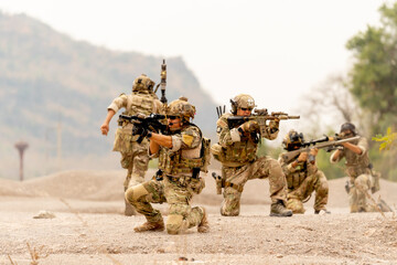 Group of soldiers or military sit and hold gun point to the enemy to practice the formation for...