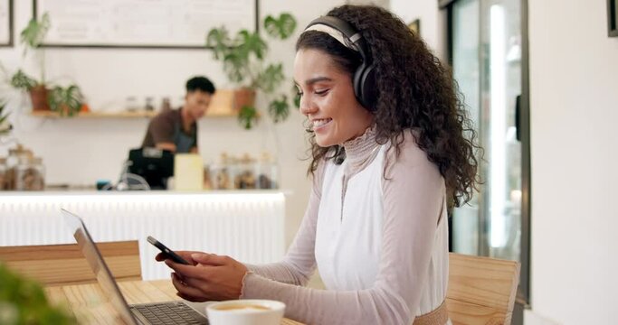 Headphones, laptop and woman on cellphone in coffee shop networking on social media or internet. Technology, smile and female creative freelancer type email on a phone and working on computer in cafe