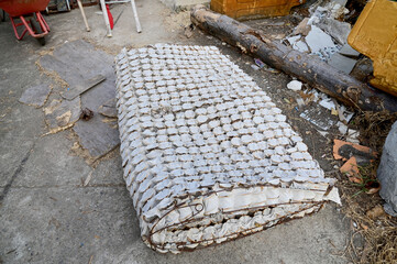 BANGKOK, THAILAND - April 11, 2024: Closeup of Spring components Inside the old mattress Left on the floor with garbage outside the accommodation building. - obrazy, fototapety, plakaty