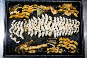 Delicious and healthy grilled eel cooked on an iron plate until yellow.