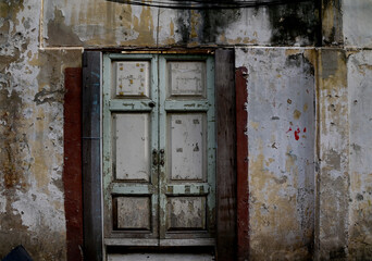 Wooden doors, old wooden windows on old walls texture pattern background at Thailand.