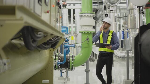 engineer work on chiller plant. worker checking pipe on chiller water plant