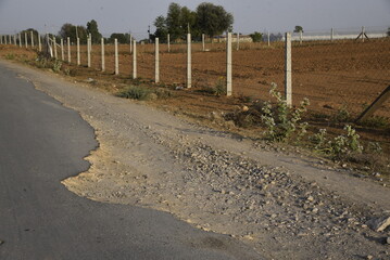 Bad road, cracked asphalt with potholes and big holes. Potholes on the road with stones on the asphalt. The asphalt surface is destroyed on the road. Bad condition of the road