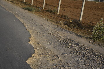 Bad road, cracked asphalt with potholes and big holes. Potholes on the road with stones on the asphalt. The asphalt surface is destroyed on the road. Bad condition of the road - 778663755
