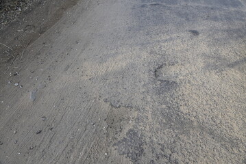 Bad road, cracked asphalt with potholes and big holes. Potholes on the road with stones on the asphalt. The asphalt surface is destroyed on the road. Bad condition of the road - 778663796