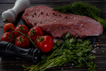 Raw beef steak with spices on a dark slate, stoneselective focus