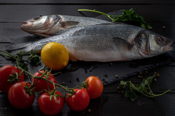 Sea bream or dorado sea fish herbs on dark slate background Top view 
