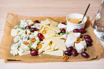 Artisan Cheese Platter with Grapes and Nuts. An assorted cheese board featuring blue cheese, brie,...
