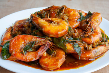 Serving Kam Heong Prawns on white plate. Delicious Asian food concept.