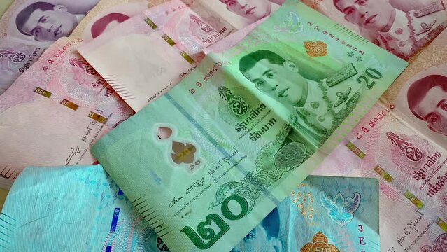 Close-up of a pile of twenty baht, fifty baht, one hundred, five hundred and one thousand Thai baht (THB) notes of Thailand. high-resolution background images.