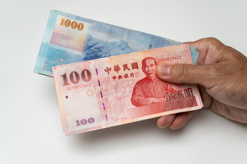 Hand holding Taiwanese dollar banknote - 778693182