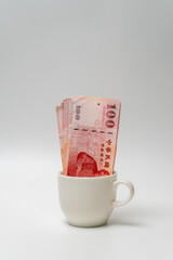 Taiwanese dollar banknote in a cup - 778693507