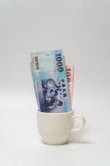 Taiwanese dollar banknote in a cup - 778693518