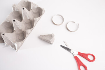 Various objects on white background, providing inspiration for cut-and-paste projects. Suitable for paper-based materials, red scissors, empty egg box