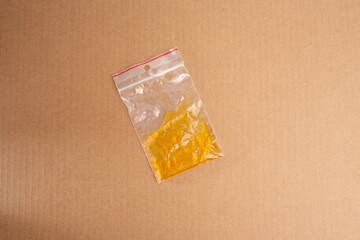 Striking minimalism, plastic bag against clean beige or brown paper backdrop, top-down view of yellow liquid, integral to crafting project for kids