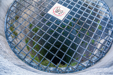 Deep circular well covered with a metal grid.