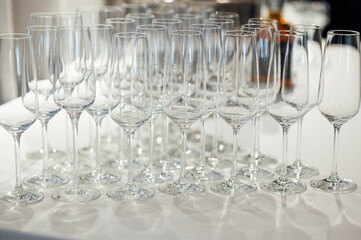 Many empty champagne glasses stand on the table