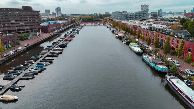 Aerial drone view of modern footbridge Python Bridge at Eastern Docklands neighborhood of Amsterdam Netherlands. High quality 4k footage