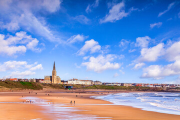 Tynemouth, Tyne and Wear, UK - People take a walk on the beach at Tynemouth on a bright spring day. - obrazy, fototapety, plakaty