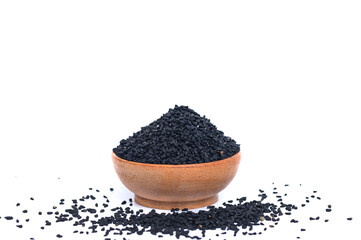 Black cumin seeds in a wooden bowl on a white background
