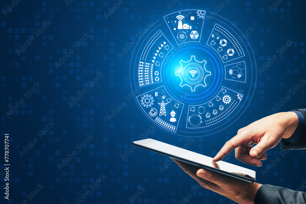 Poster Close up of businessman hand pointing at mobile phone with round digital cogwheel and other icons hologram on blue background with mock up place. Tech support and innovation concept.
