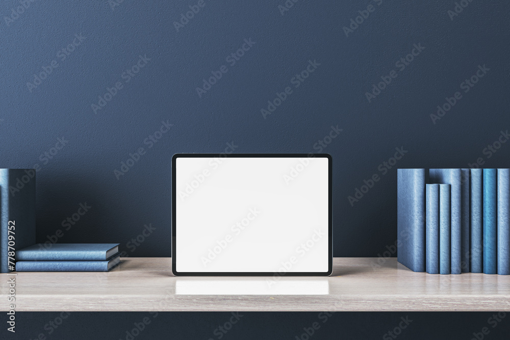 Poster close up of creative wooden designer desk with books and empty white mock up tablet on blue concrete