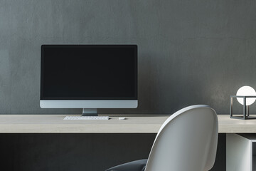 Close up of contemporary mock up computer screen at modern designer office workplace in interior. Concrete wall background. 3D Rendering.