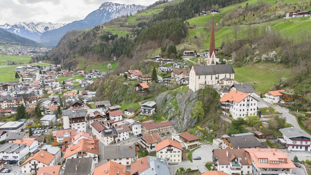 Aerial drone view of Oetz village during early springtime. Famous church standing on a rock in the Austrian village Oetz in &Ouml;tztal valley. Mountains in the background.