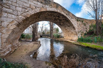 Fototapeta na wymiar Roman stone bridge over a small stream that crosses the city of Aranda de Duero, Burgos.