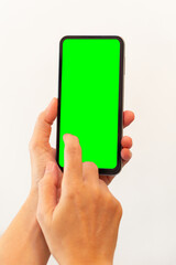 women hand holding smart mobile phone with blank green screen on isolated white background