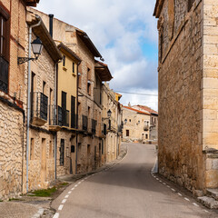 Picturesque street with stone houses in an old village of Castilla Leon, Burgos.