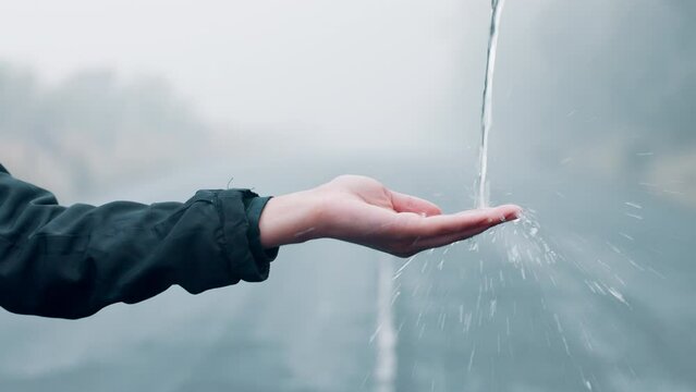 Hand, water and splash outdoor for sustainability, person for health and hygiene with handwashing rewind, fresh and clean. Liquid mineral, wellness and drop, backtrack with rain or storm in nature
